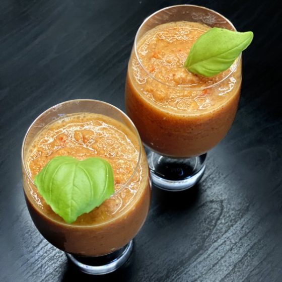 gaspacho dans deux petits verres avec feuilles de basilic