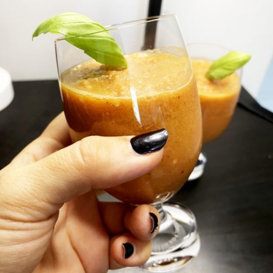 gaspacho dans deux petits verres avec feuilles de basilic
